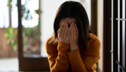 woman covering her face with both hands